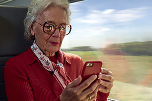 Photo illustrant une personne qui regarde son téléphone dans le train 